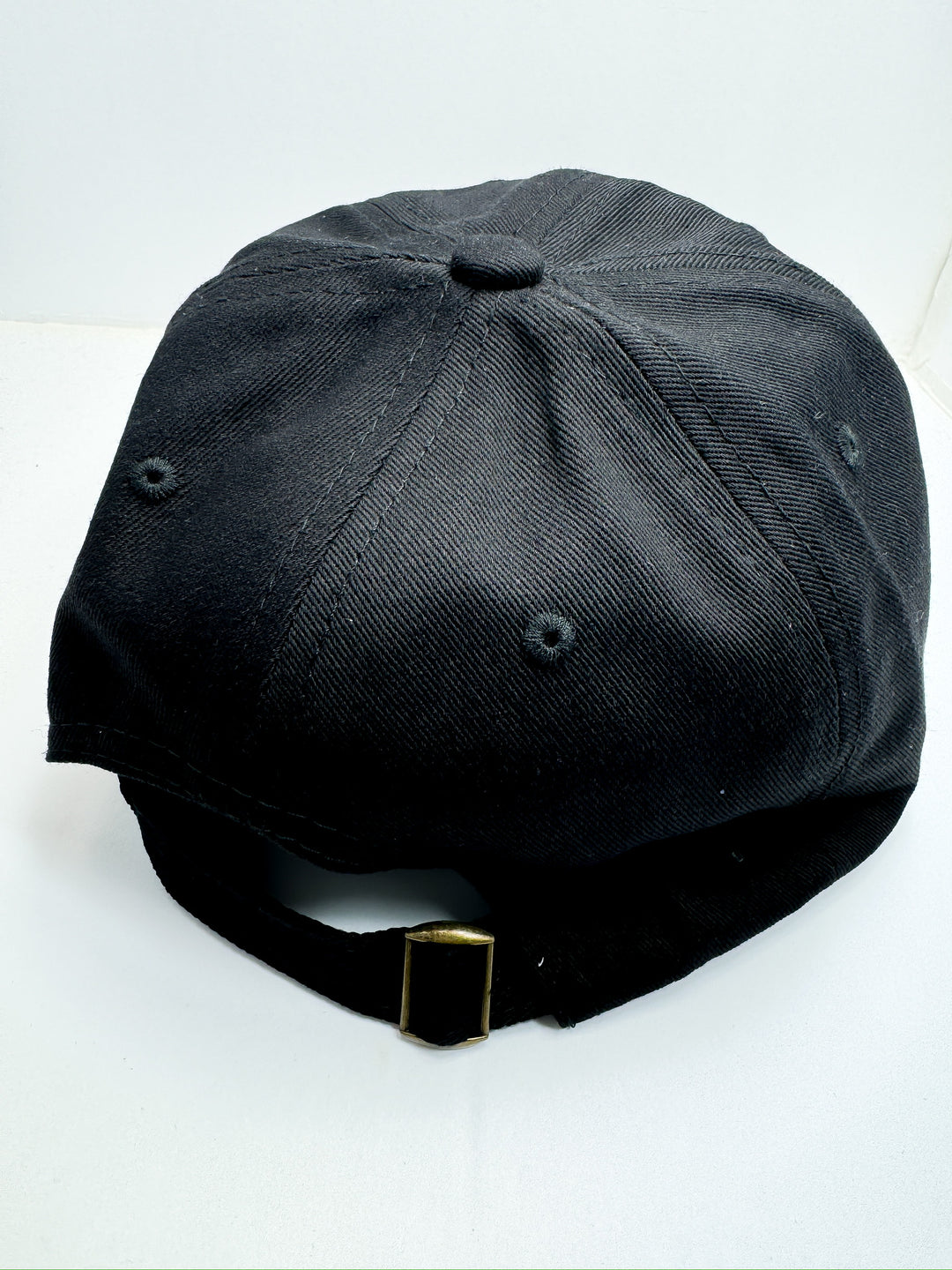 A black baseball cap with an adjustable strap, featuring a brown textured design on the front with the word 'FOOTBALL' and a brown football icon.