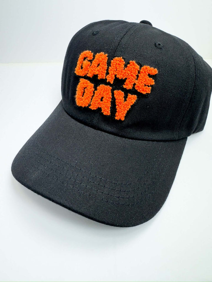 A black baseball cap with the text 'Game Day' embroidered in orange on the front.