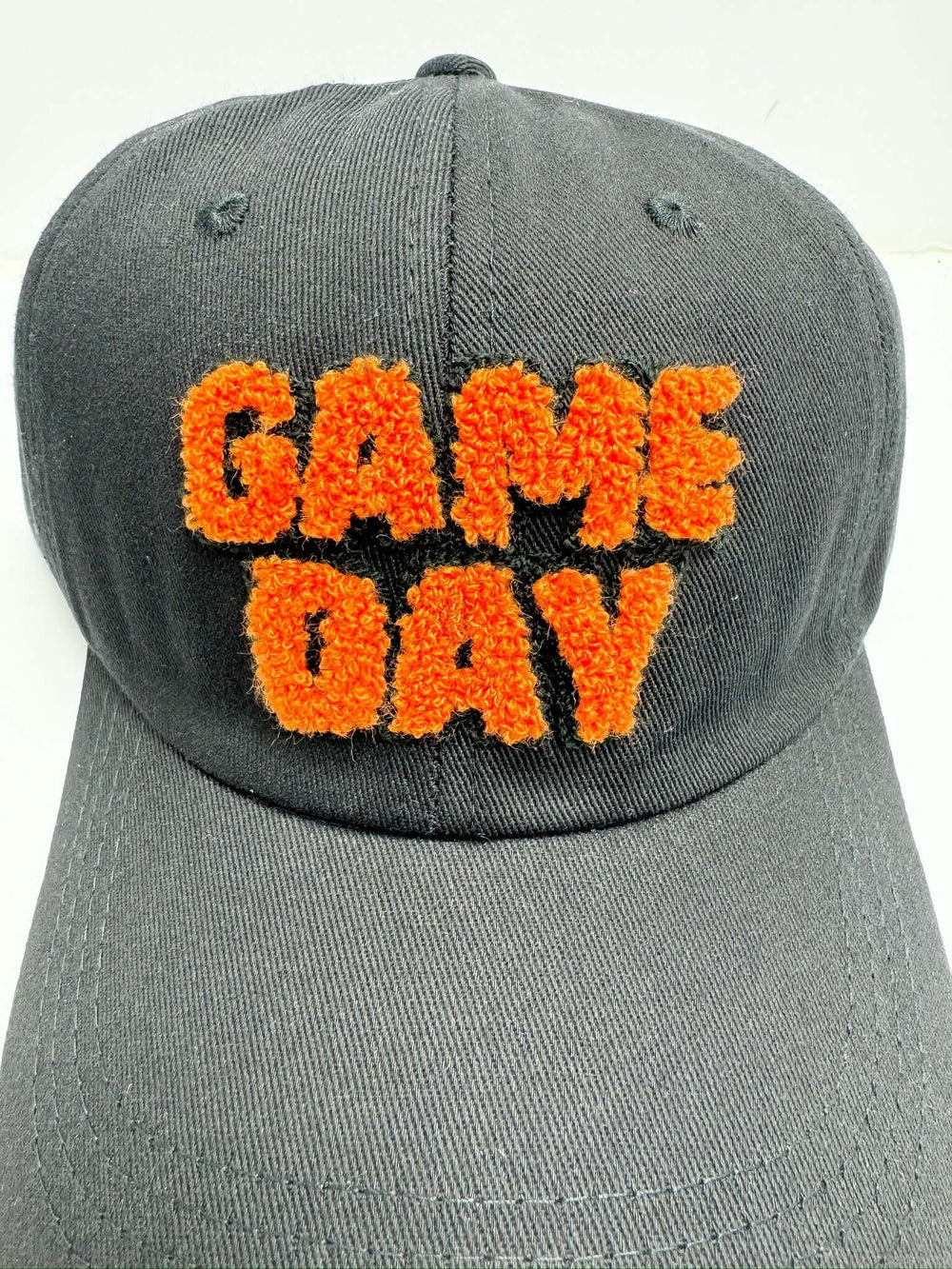 A black baseball cap with the text 'Game Day' embroidered in orange on the front.