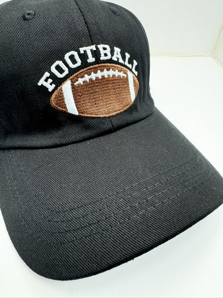A black baseball cap with an adjustable strap, featuring a brown textured design on the front with the word 'FOOTBALL' and a brown football icon.