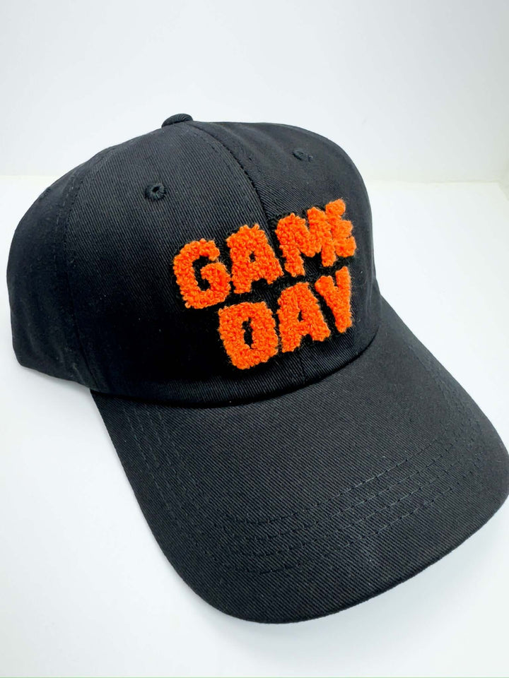 A black baseball cap with the text 'Game Day' embroidered in orange on the front.