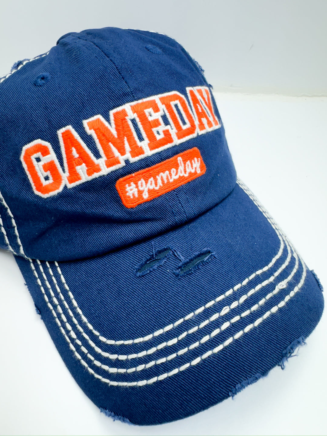 A blue and orange striped baseball cap with 'Game Day' text in orange on the front.