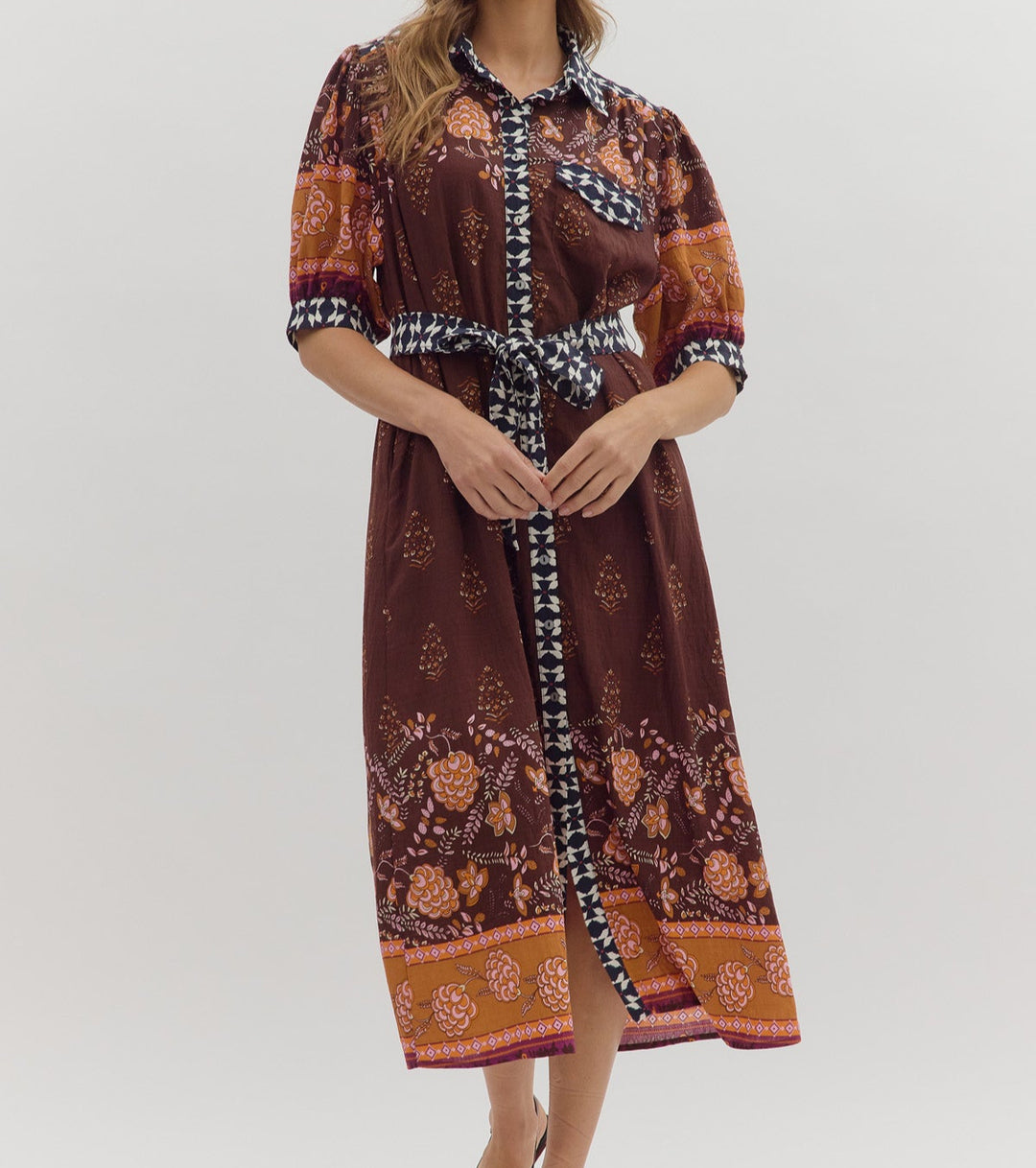 Woman wearing a patterned dress on a white background
