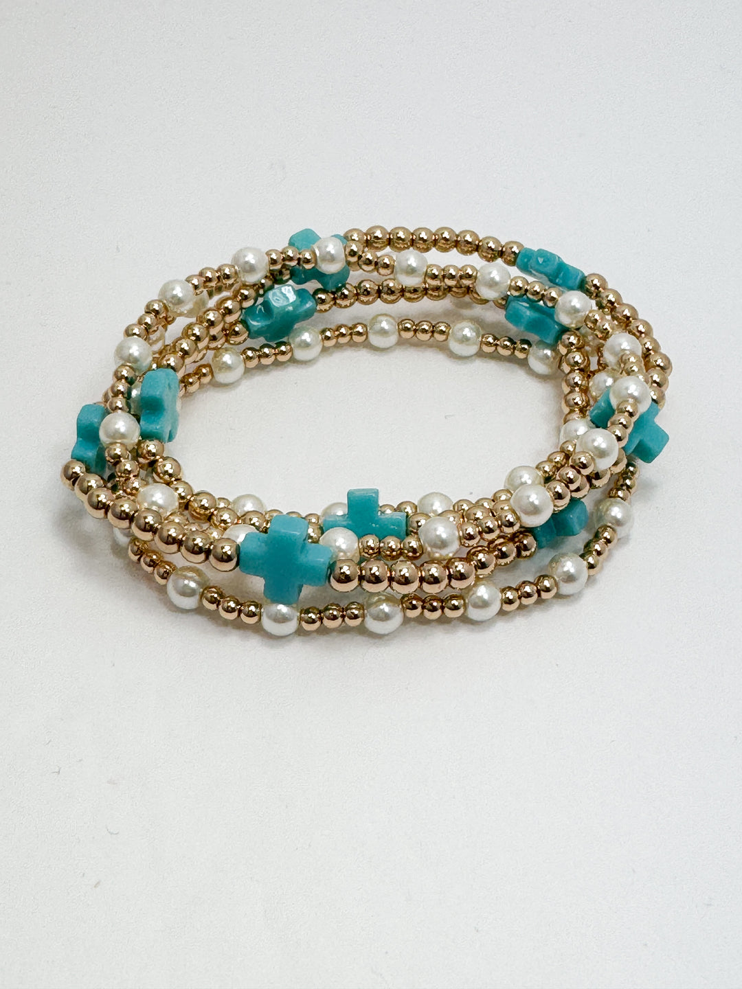 Multistrand bracelet with turquoise and gold beads on a white background