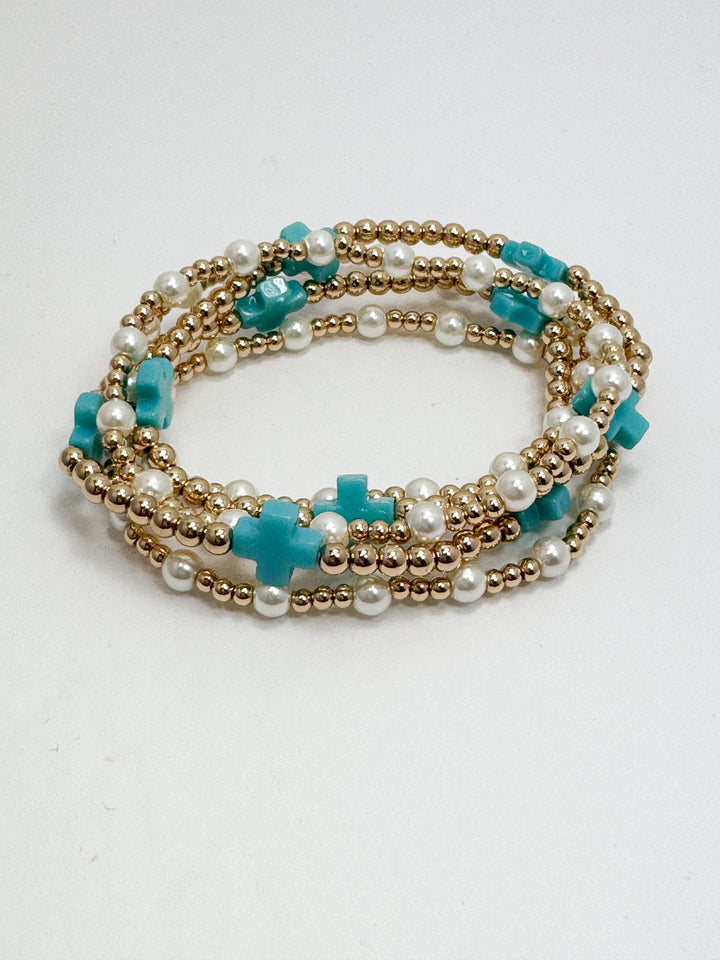 Multistrand bracelet with turquoise and gold beads on a white background