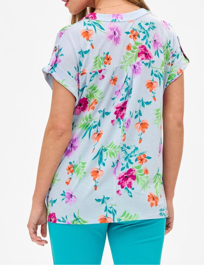 Woman wearing a colorful floral-patterned shirt on a white background
