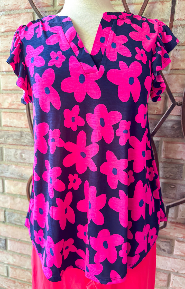 Navy blue dress with pink floral pattern on a mannequin against a wooden background