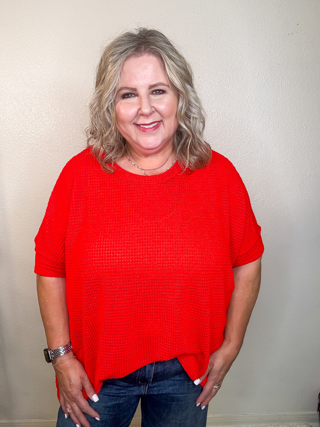 Person wearing a red shirt against a plain background