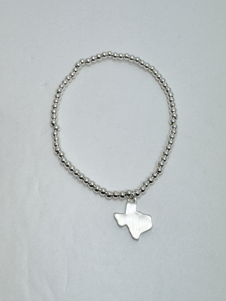 Silver beaded bracelet with a star-shaped charm on a light gray background