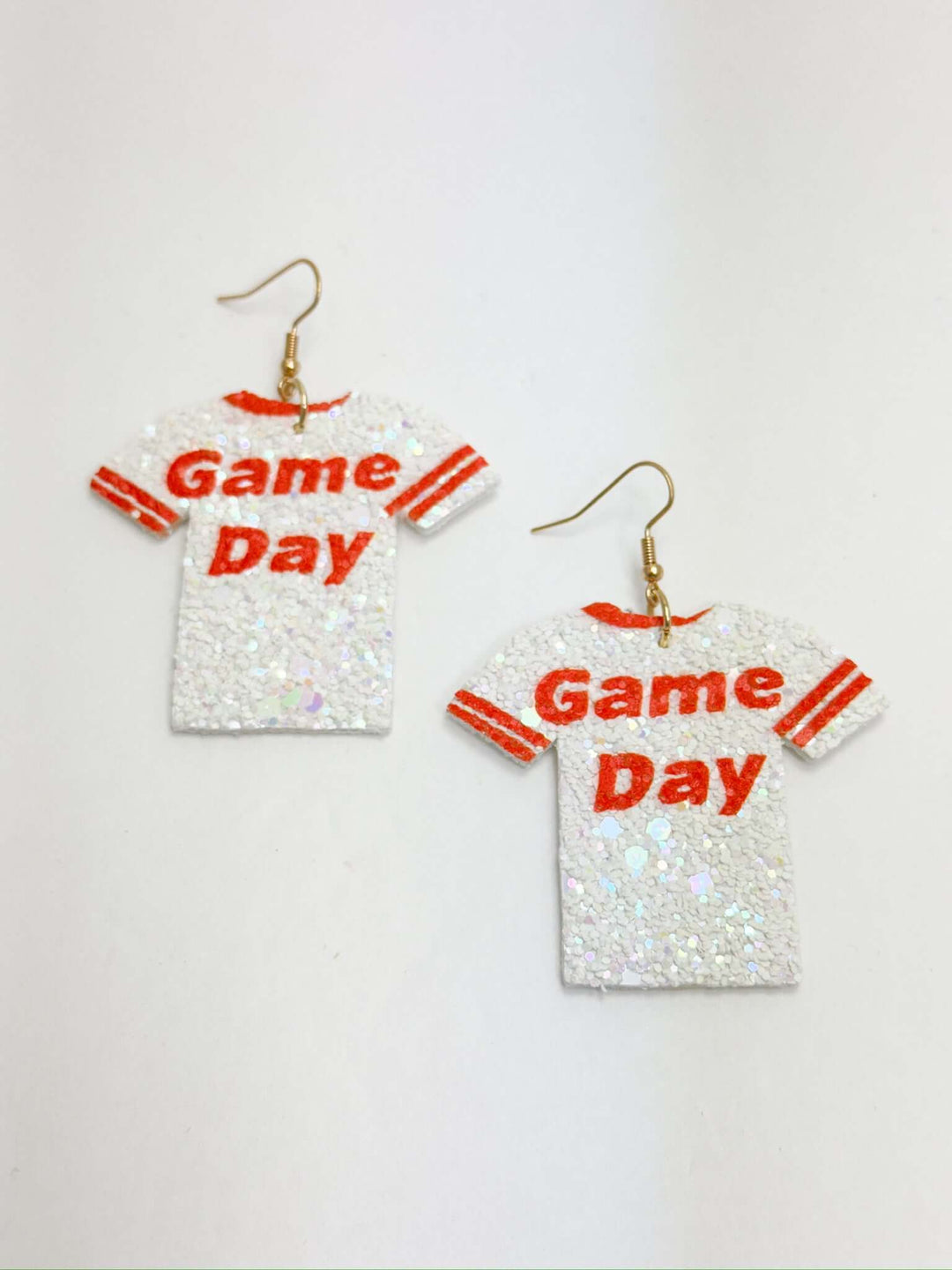 A pair of orange and white game day earrings with sequins, designed with a lightweight foam-like material.