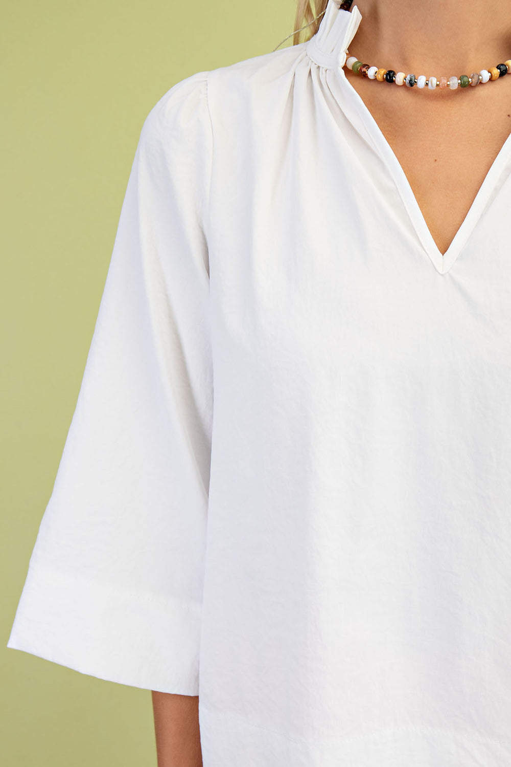 white top with ruffle collar and wide sleeves on model