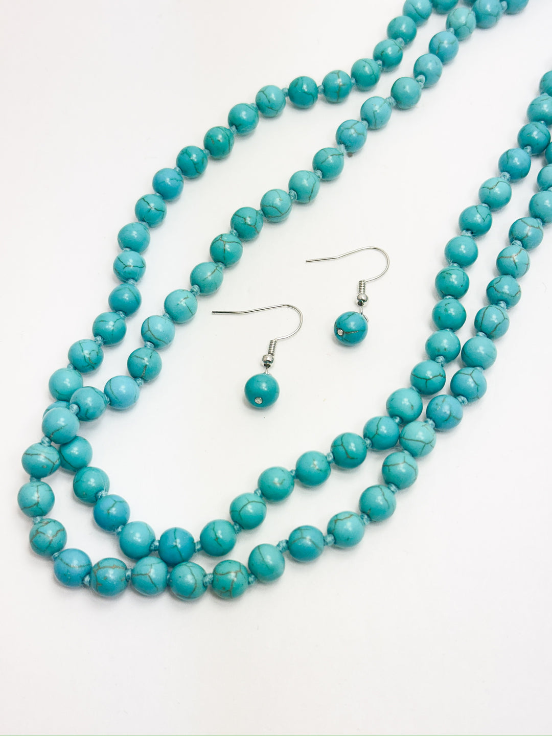 A set of turquoise bead necklace and matching earrings, displayed on a white background.