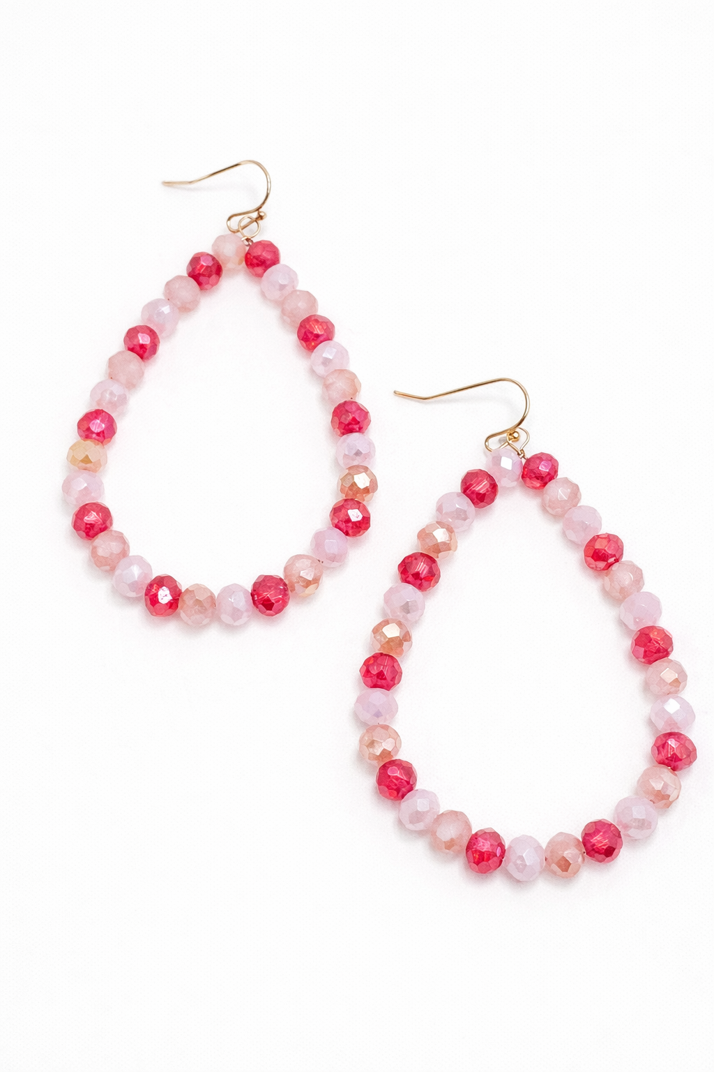 Pair of pink beaded hoop earrings on a white background