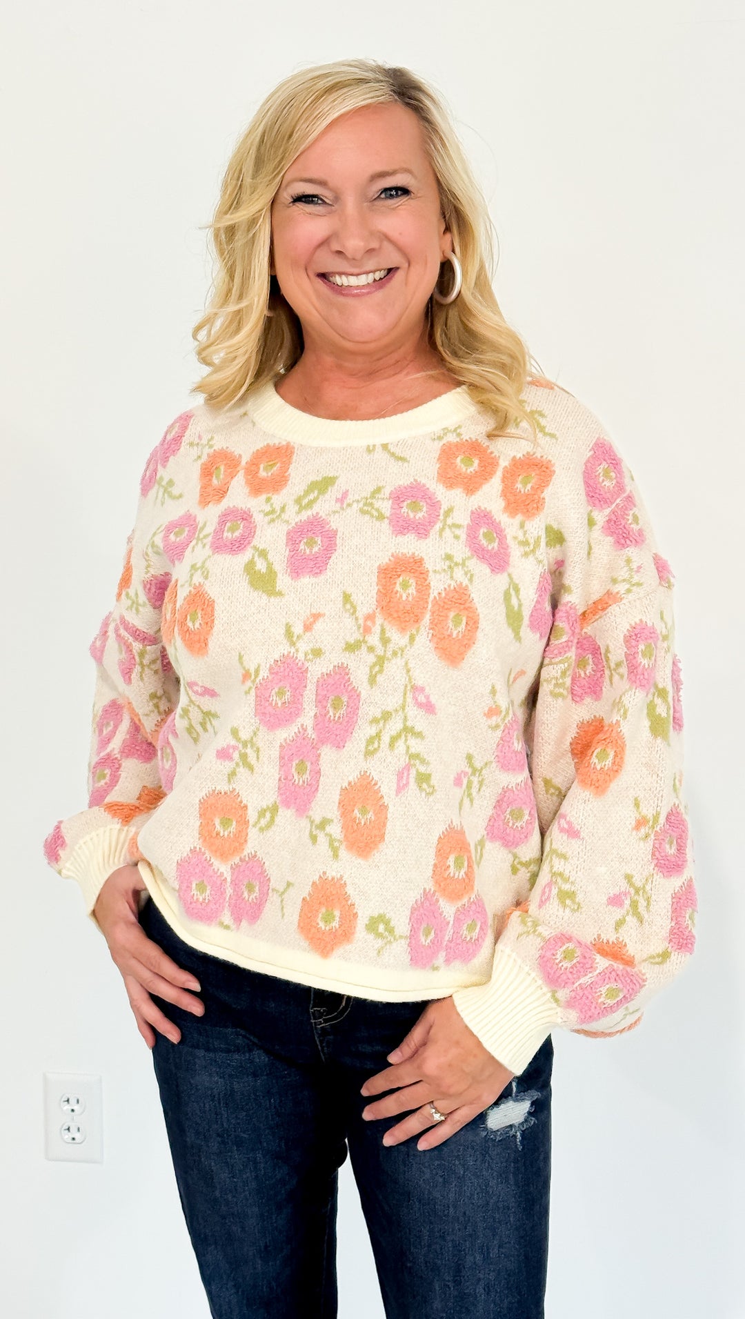 Woman wearing a floral sweater with a plain background