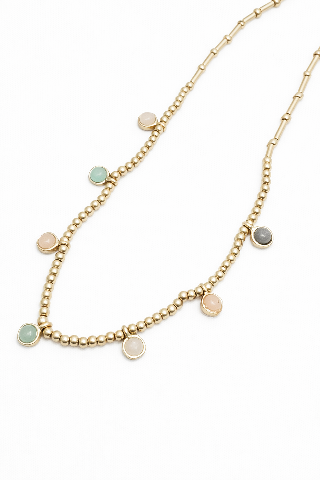 Gold necklace with small round beads on a white background