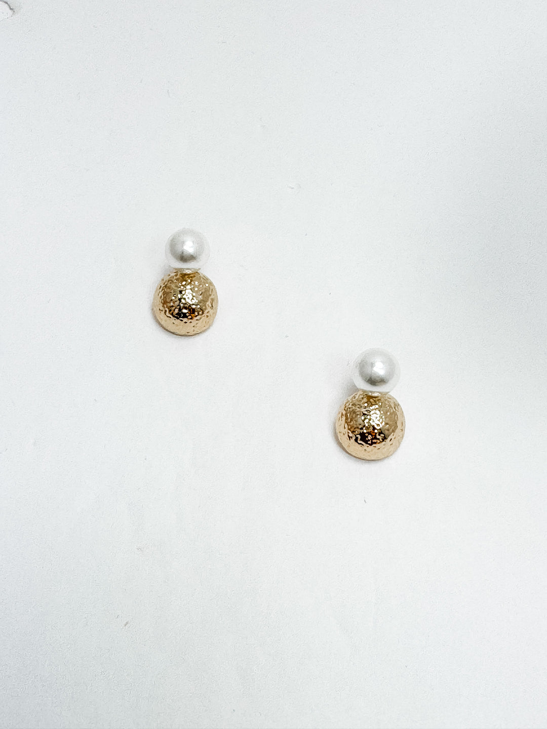 gold and pearl post earrings on white background