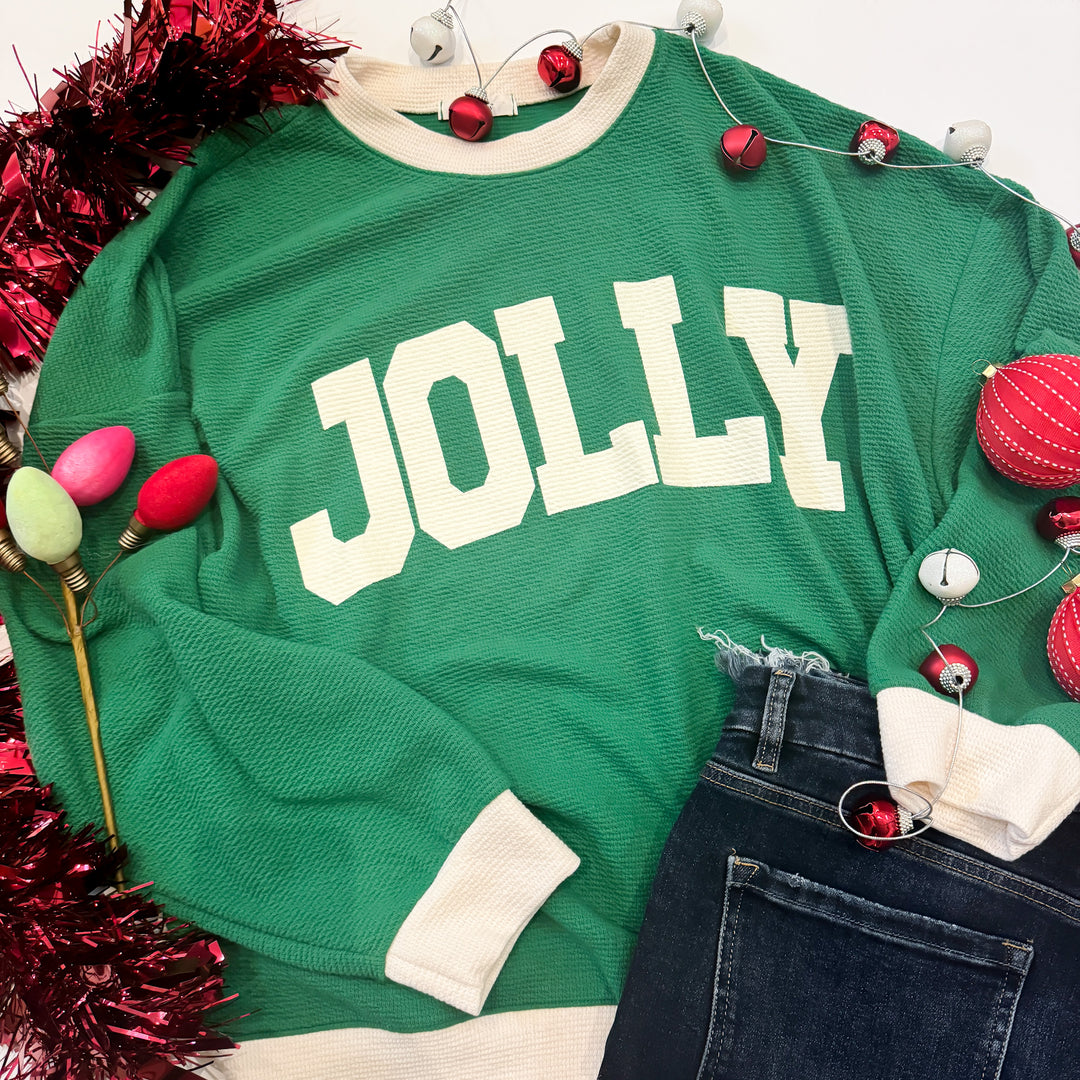 Green sweater with 'JOLLY' text surrounded by Christmas decorations