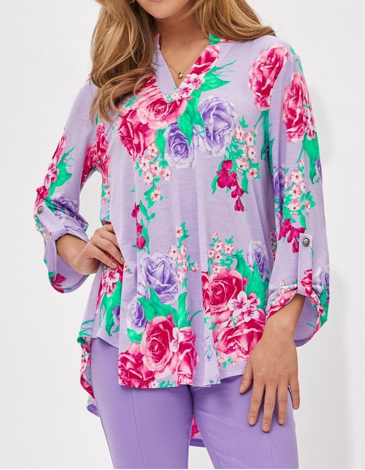 Woman wearing a colorful floral blouse with a white background