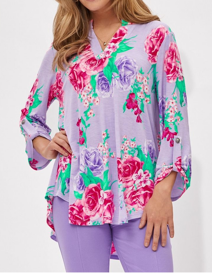 Woman wearing a colorful floral blouse with a white background