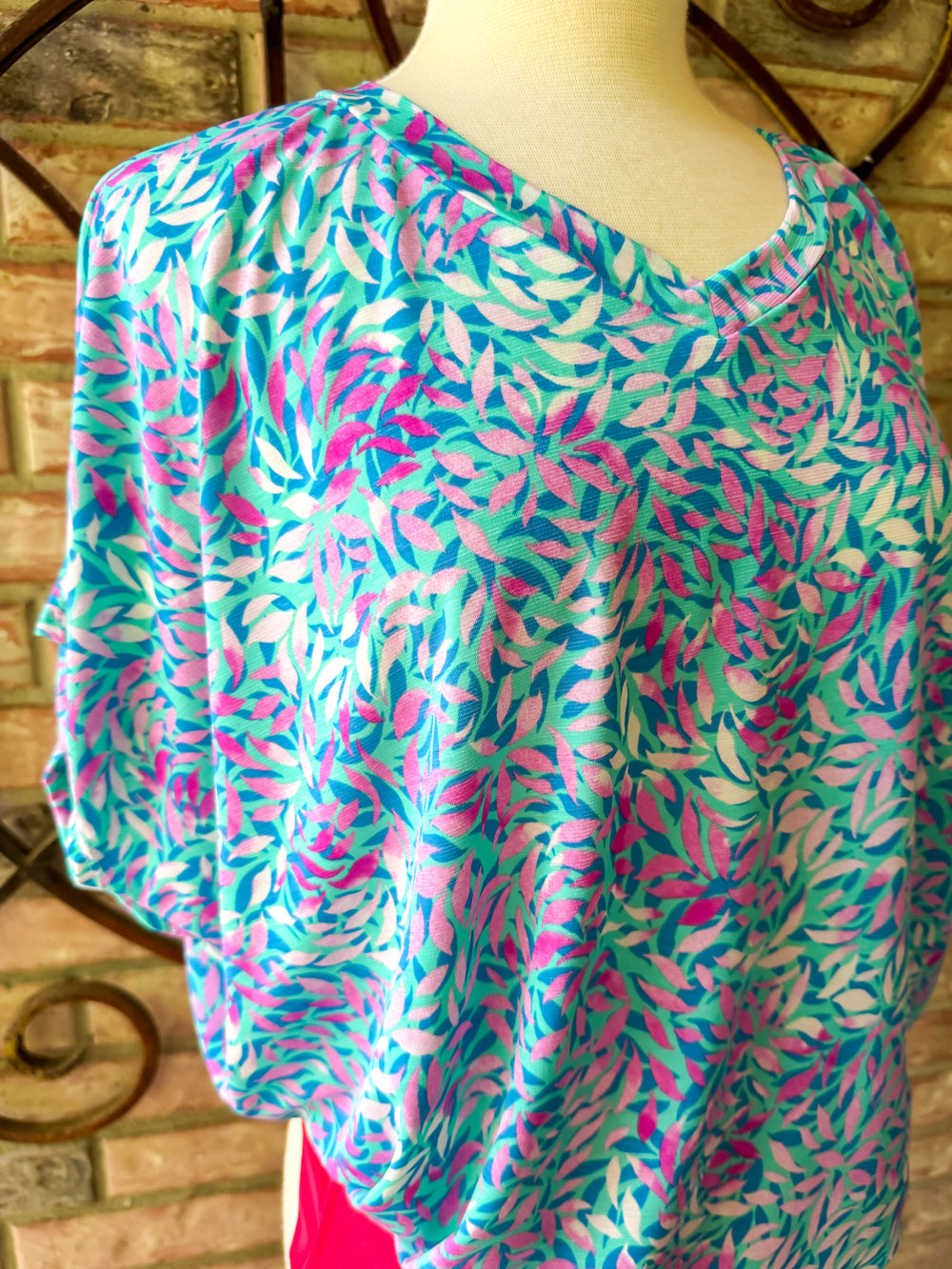 Colorful patterned top on a mannequin against a rustic wooden background