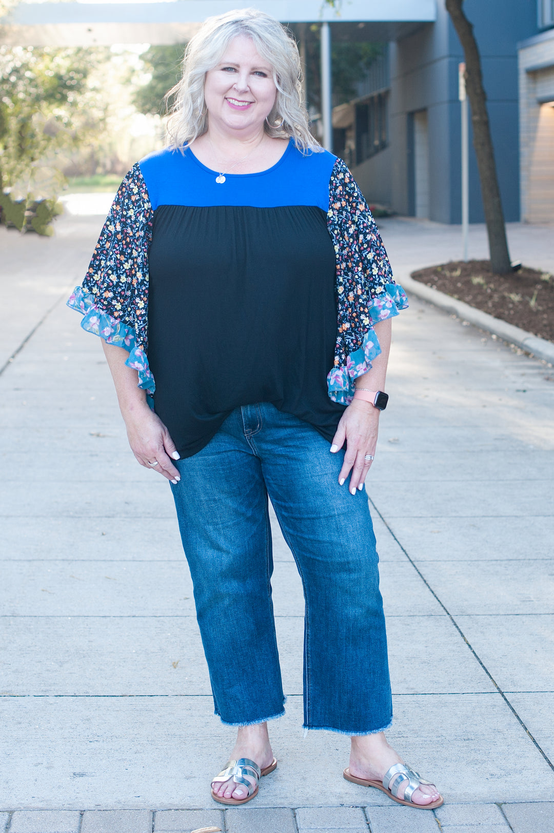 model wearing a blue and black top and jeans