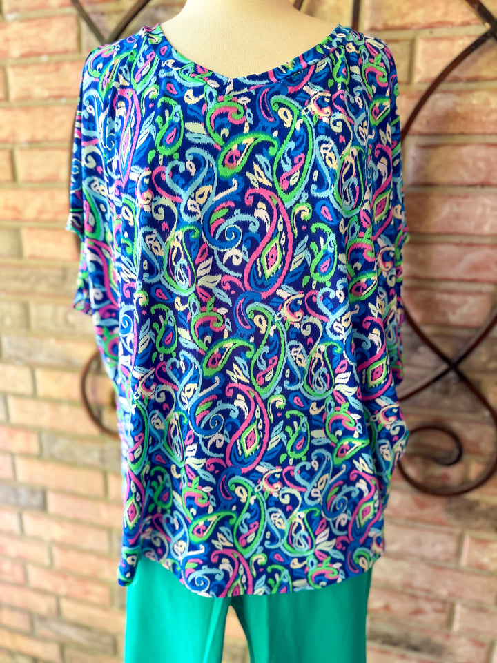 Colorful patterned top on a mannequin against a brick wall background