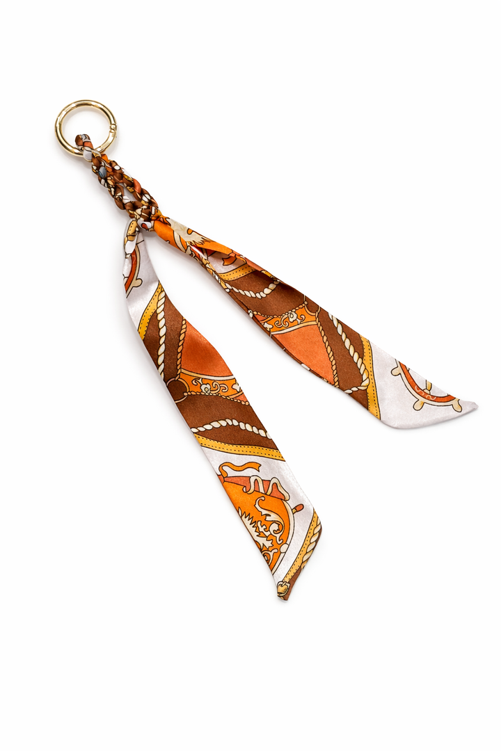 Decorative keychain with orange and white pattern on a white background