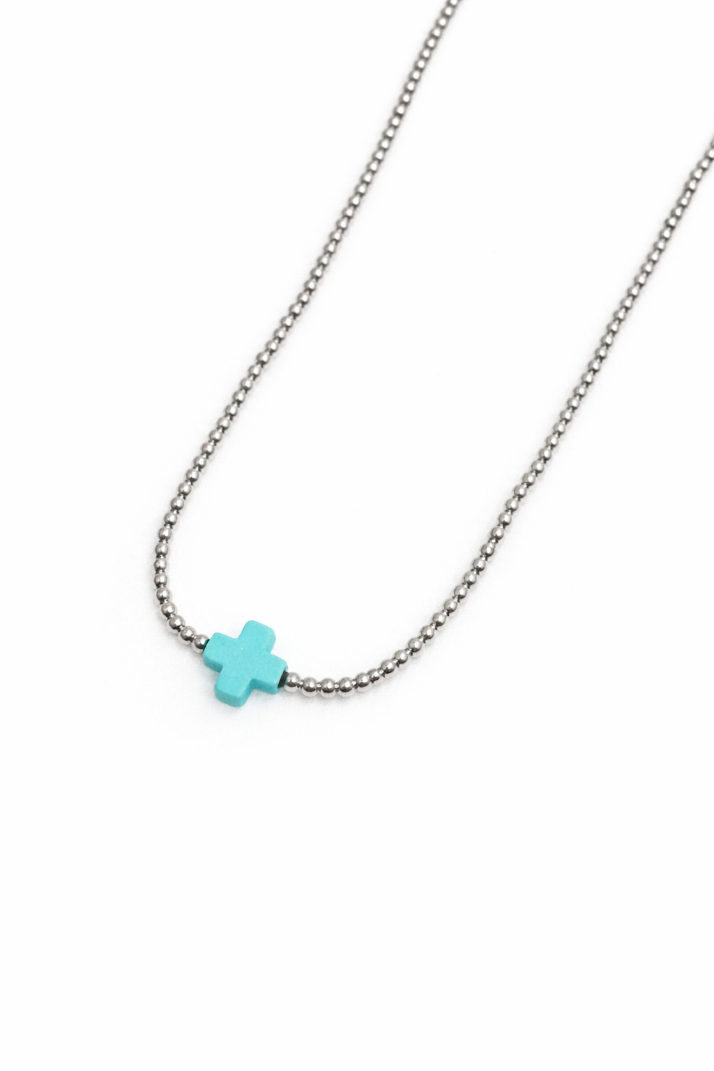 Necklace with a turquoise cross pendant on a white background